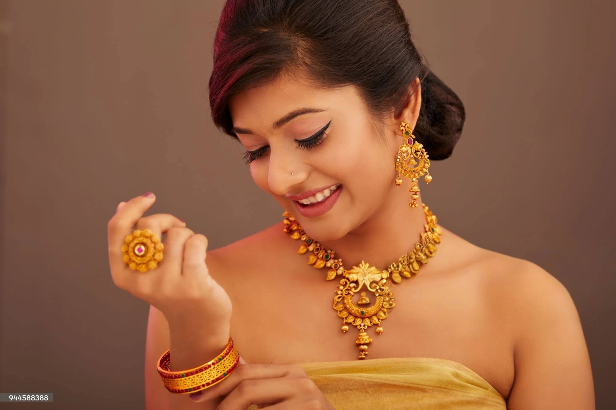 An indian woman wearing gold jewelry